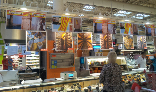 Affiches au rayon fromage de Auchan Perpignan représentant Collioure, Le Castillet, des danseurs catalans, le pourou, et "les Vigatanes" : tableau de Carole Alexandre, au rayon fromage de Auchan Perpignan