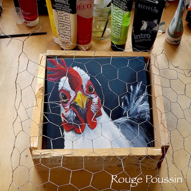 Encadrement d'un coq avec un cadre et du grillage comme s'il était dans un poulailler. Tableau de la série "Viens ma poule, on se casse"